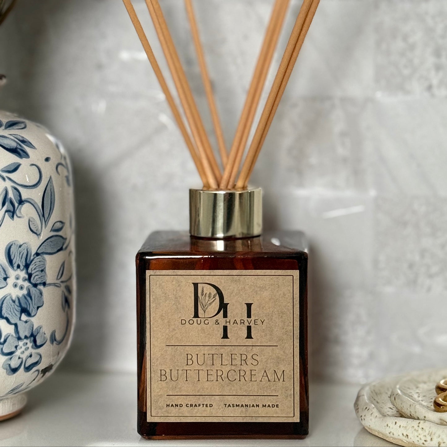 Diffuser with wooden sticks and a decorative label on a textured surface