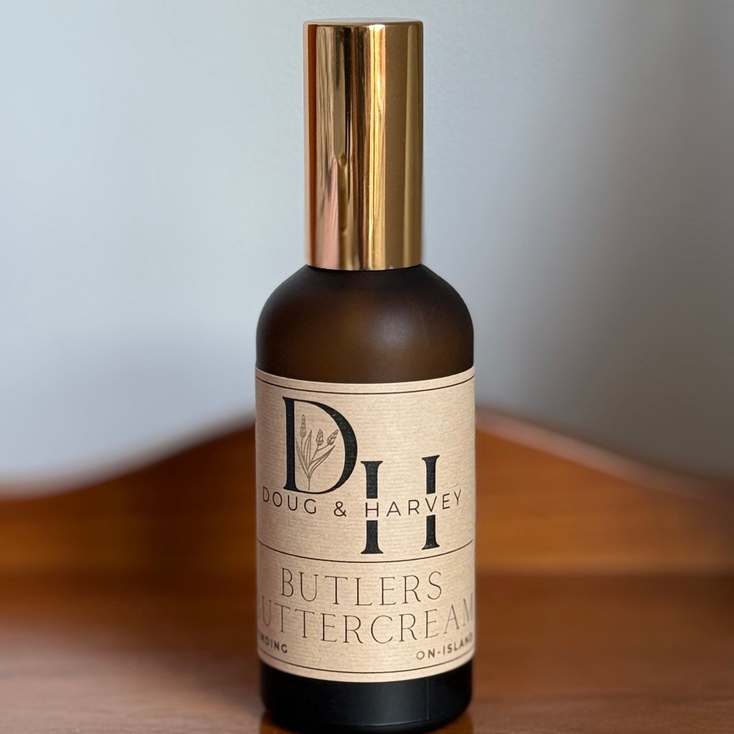 Bottle of Butlers Buttercream room and linen spray on a wooden surface with a neutral background