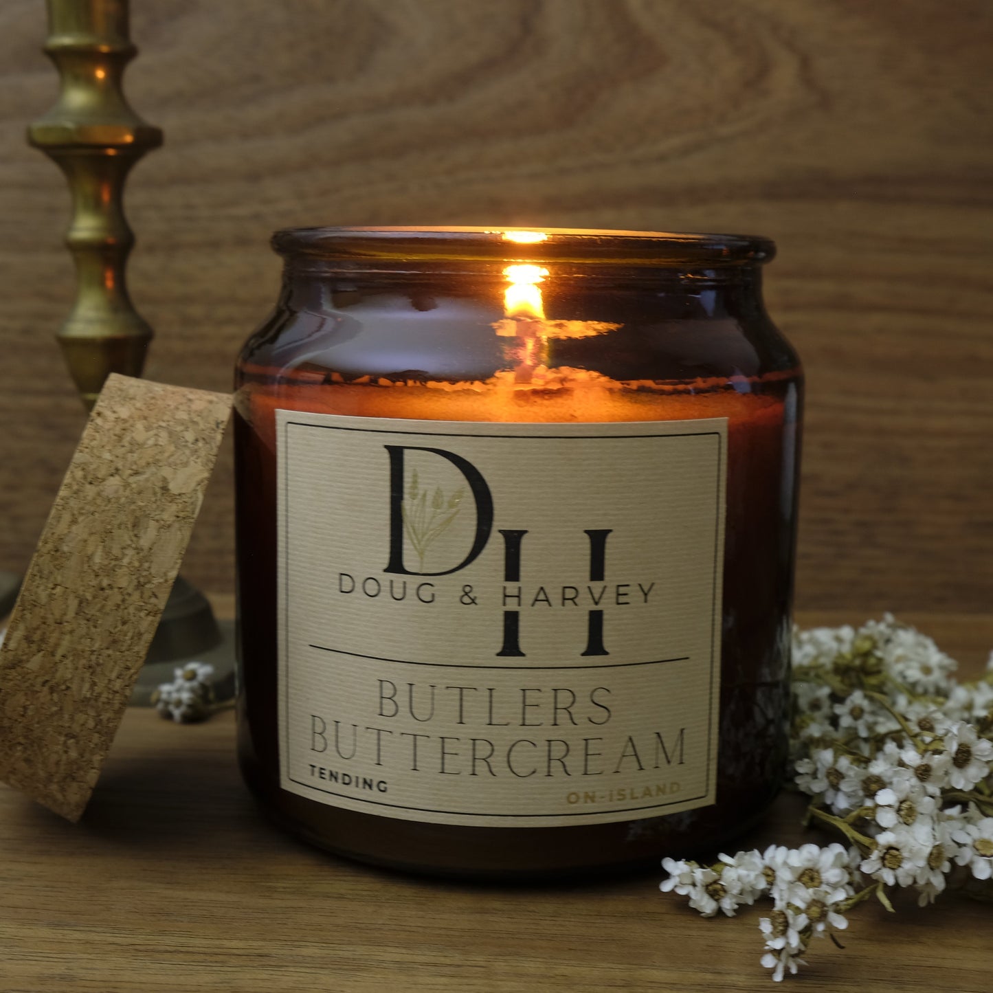 Candle with a label on a wooden surface with decorative elements