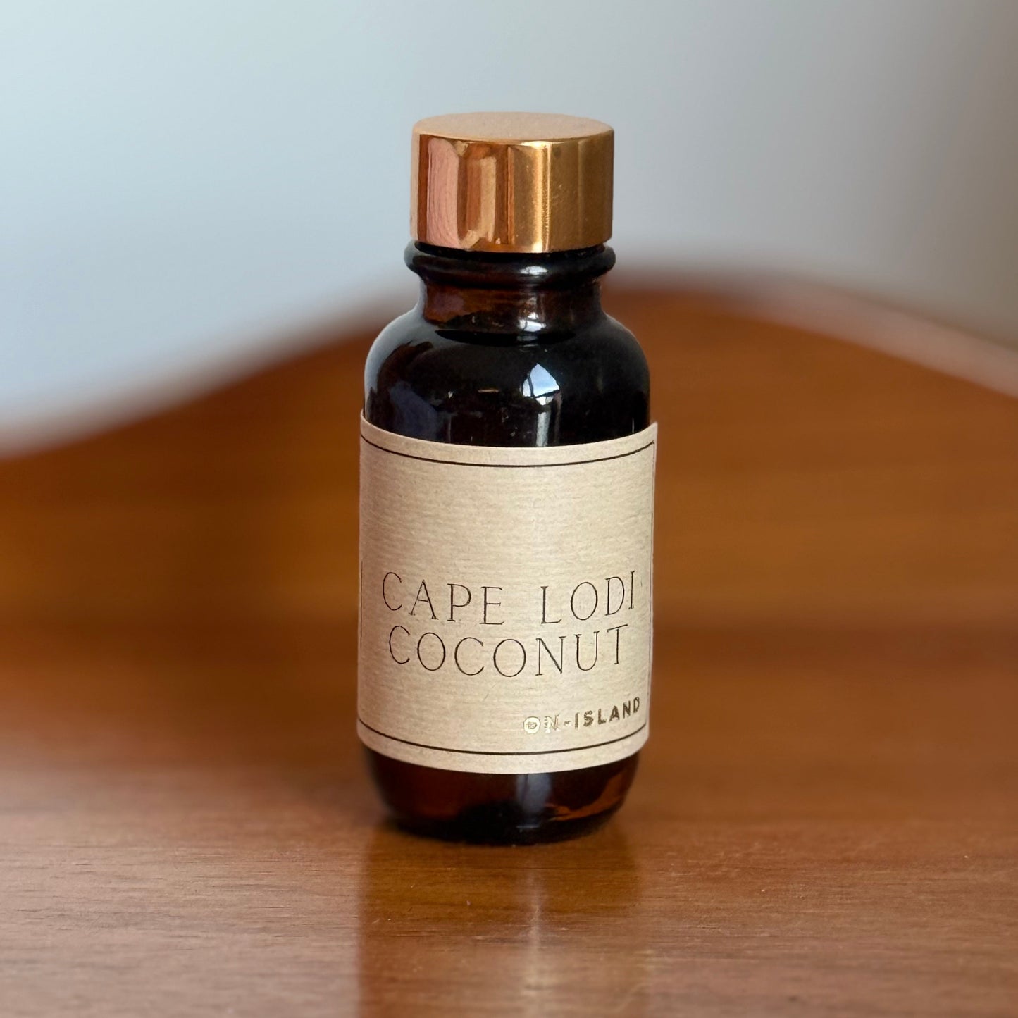 Small brown bottle with a gold cap on a wooden surface