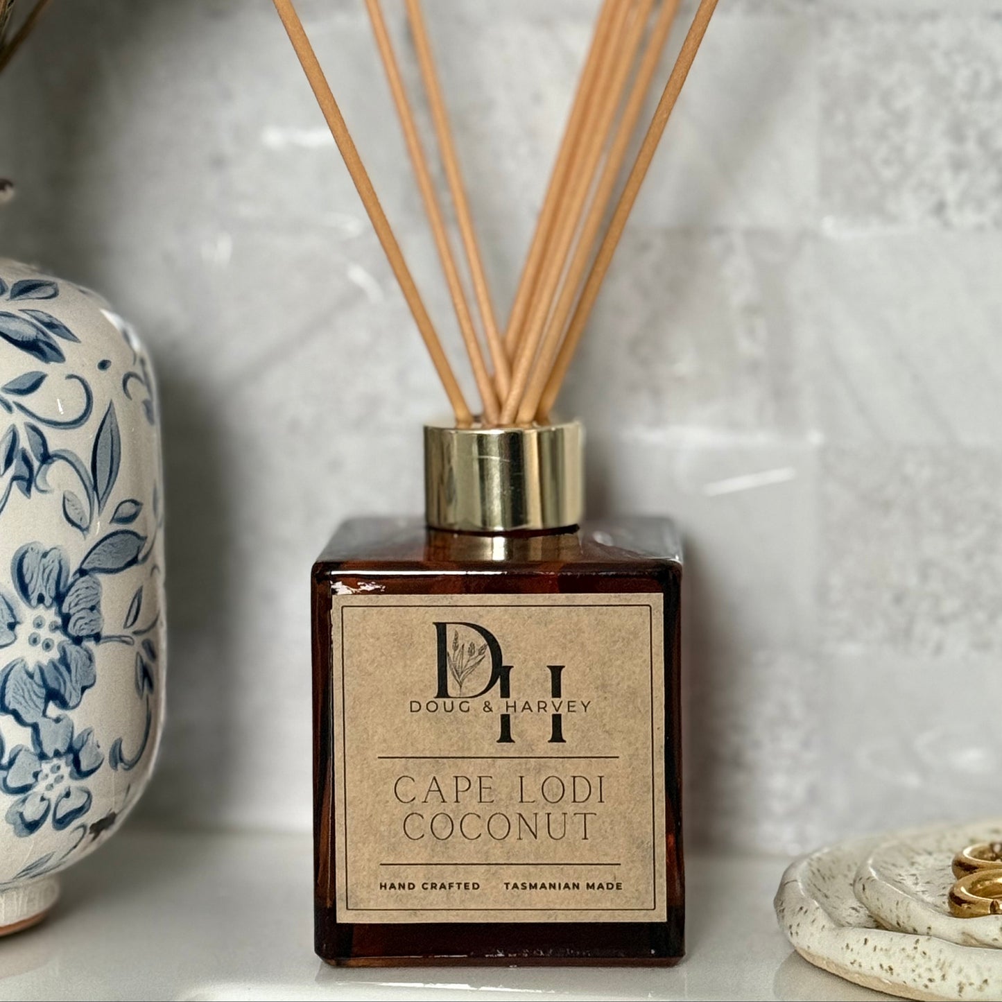 Diffuser with wooden sticks and decorative label on a textured surface