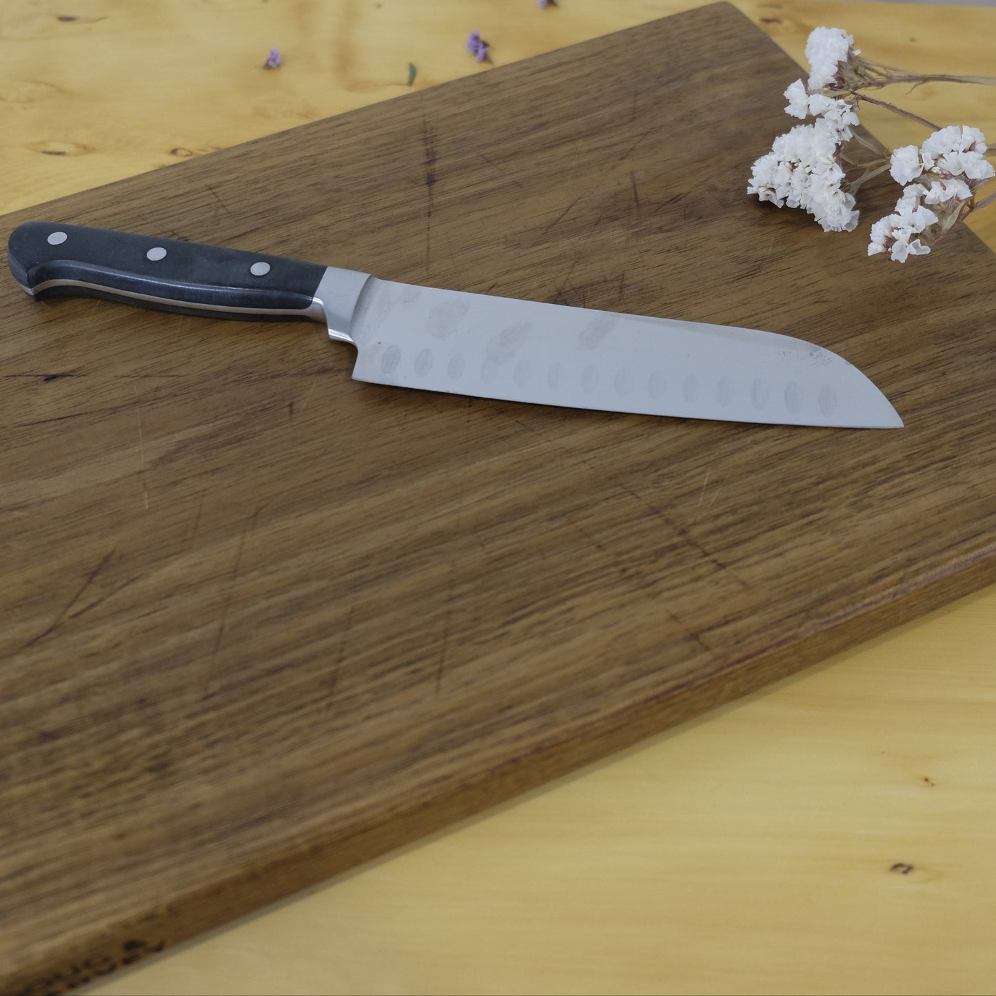 Wooden cutting board with a knife on a wooden surface