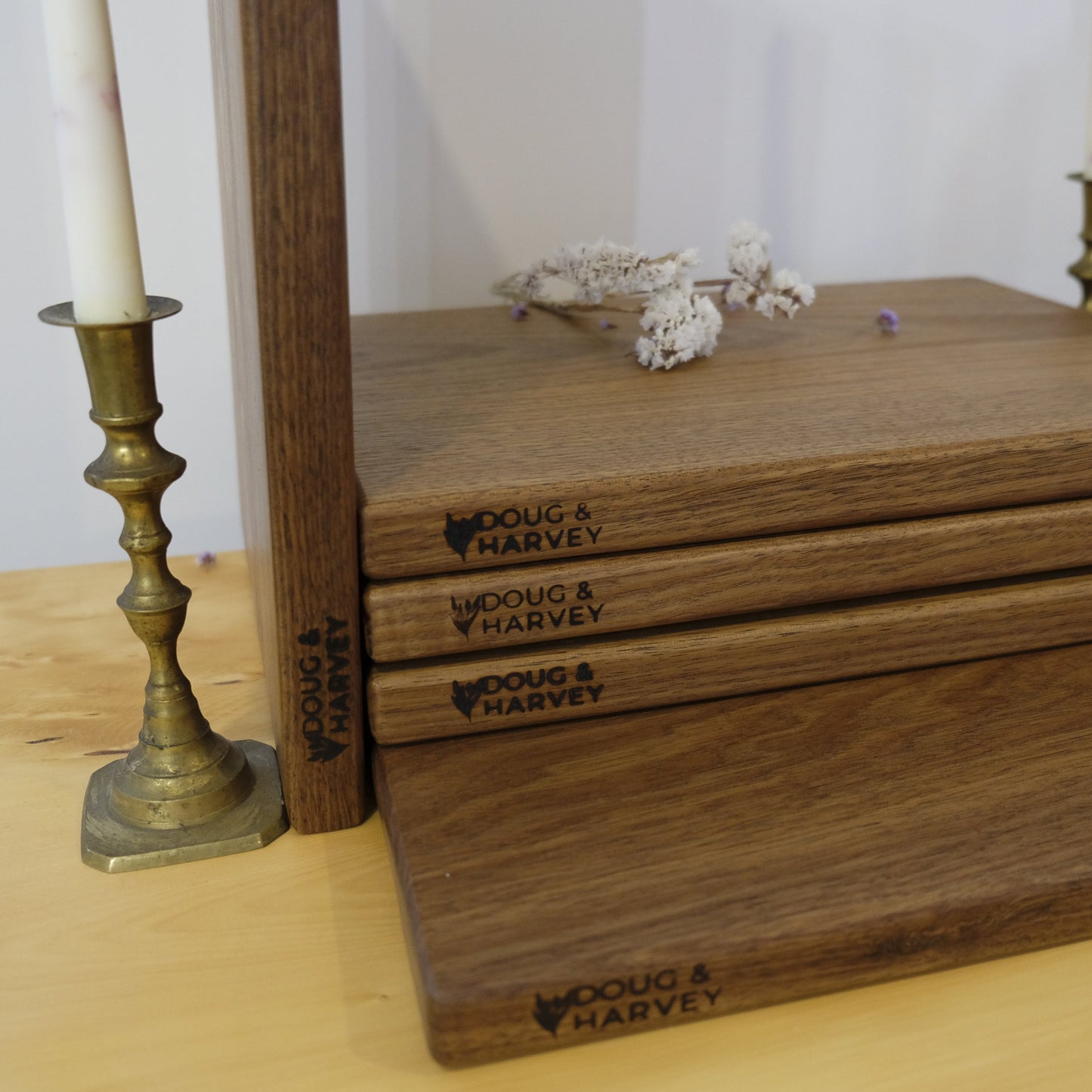 Stack of wooden cutting boards with 'Doug & Harvey' branding on a wooden surface.