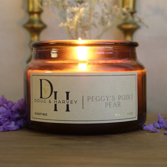 Candle with a label featuring the brand 'Dove & Harney' on a soft focus background.