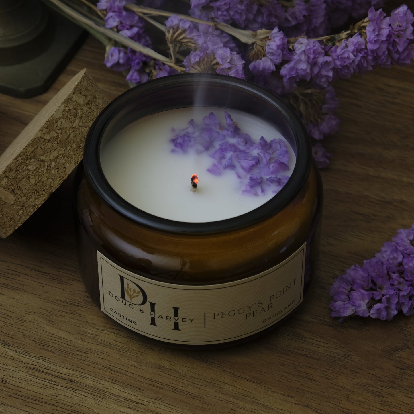 Candle with lavender flowers on a wooden surface