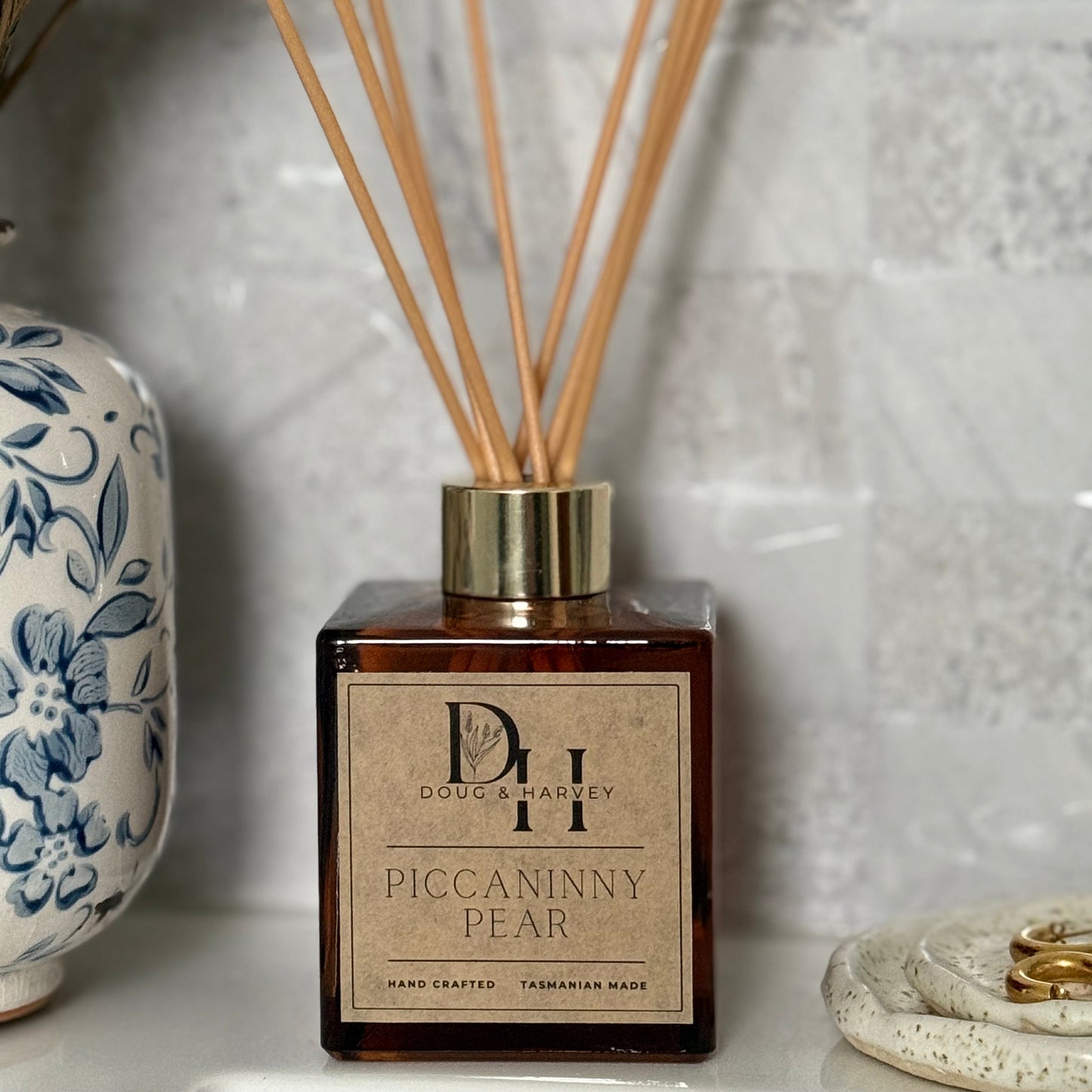 Diffuser bottle with reeds and decorative elements on a light background
