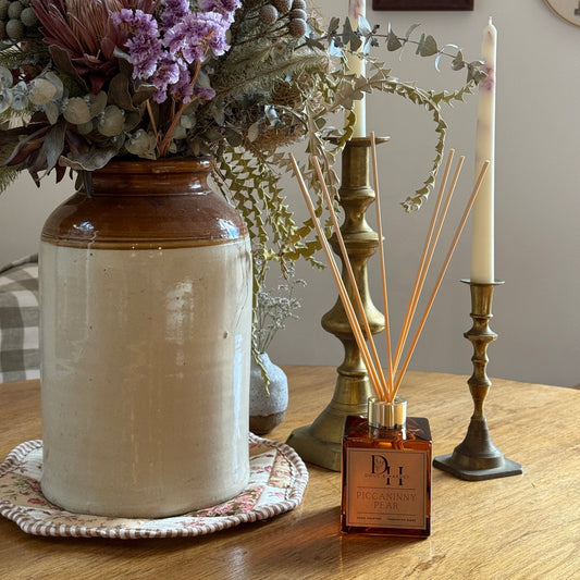 Natural reed diffuser in french pear scent set in front of country table scene