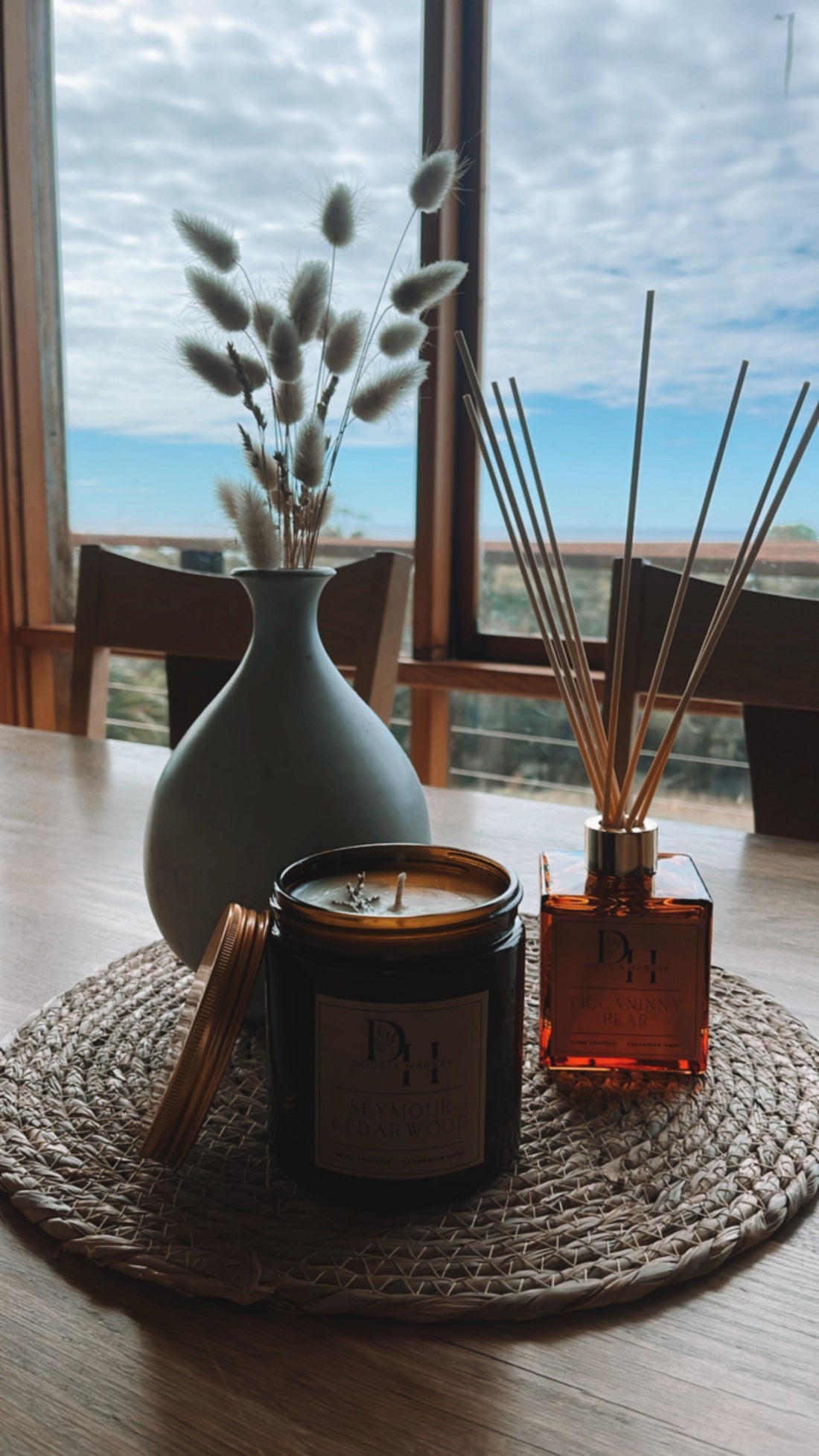 Doug & Harvey reed diffuser in a classic country-style glass bottle with natural rattan reeds, set against a backdrop of the Australian bush, bringing a refreshing fragrance and a touch of nature into a cosy home.