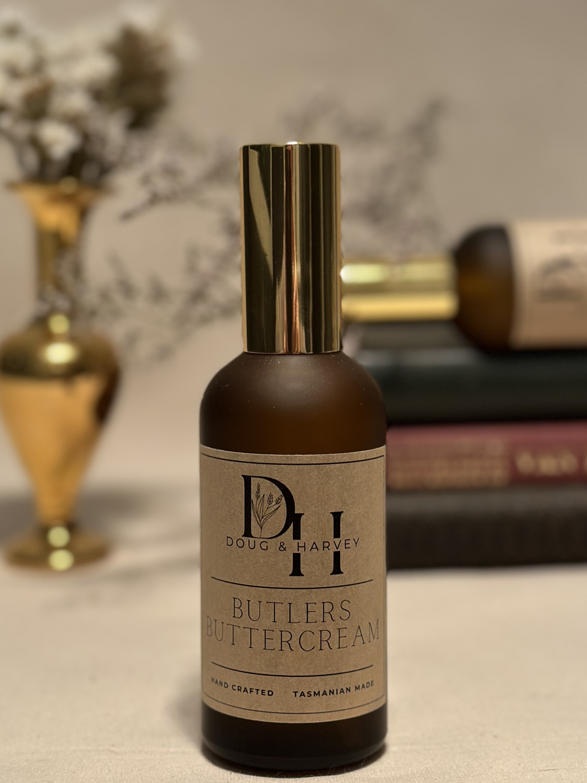 A brown glass perfume bottle showcasing the indulgent Doug & Harvey Butlers Buttercream fragrance. The bottle features a gold atomizer and a handcrafted label, highlighting its Tasmanian origin