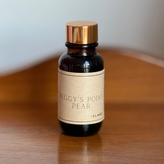 Small bottle with a gold cap and beige label on a wooden surface