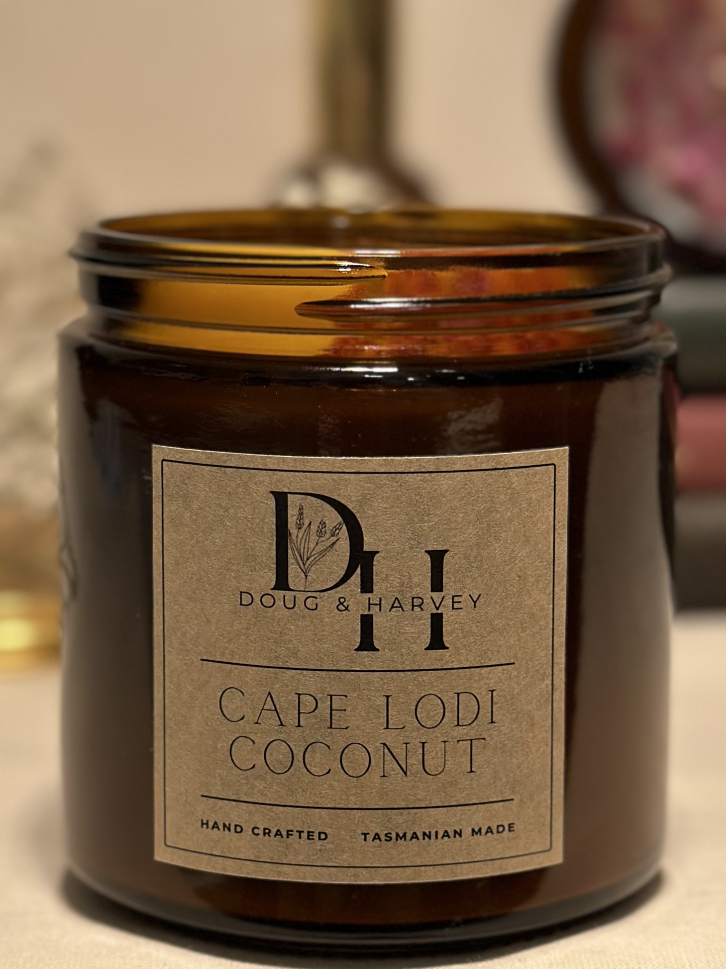 Large Cape Lodi Coconut Cocosoy wax candle in amber glass jar with gold lid, kraft brown label with black writing, adorned with native dried flowers, hand poured in Tasmania