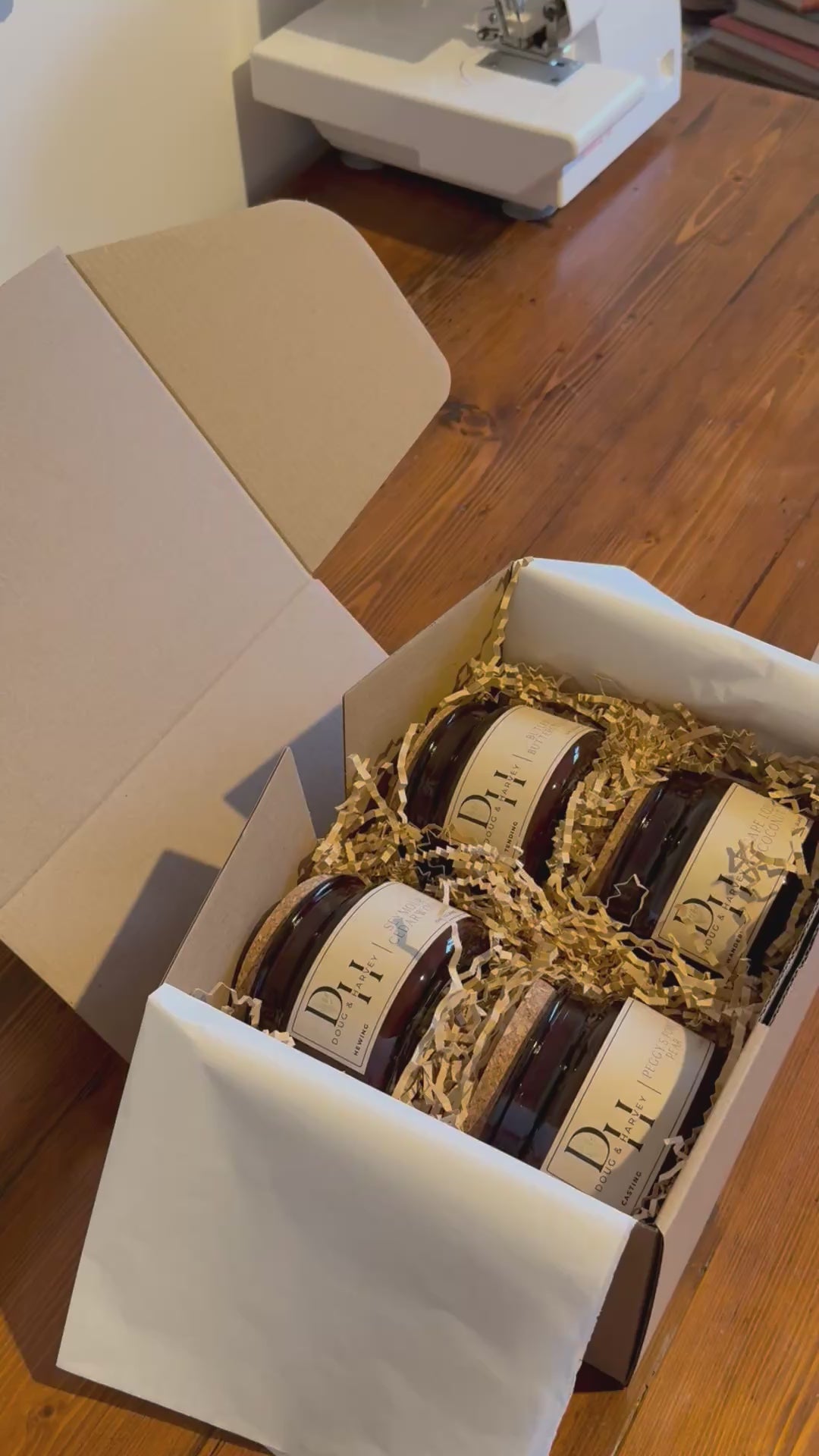 Doug & Harvey luxury amber glass candle jars and cork lid match jars packed in a gift box with natural crinkle paper on a timber table, styled in a warm Tasmanian country aesthetic.
