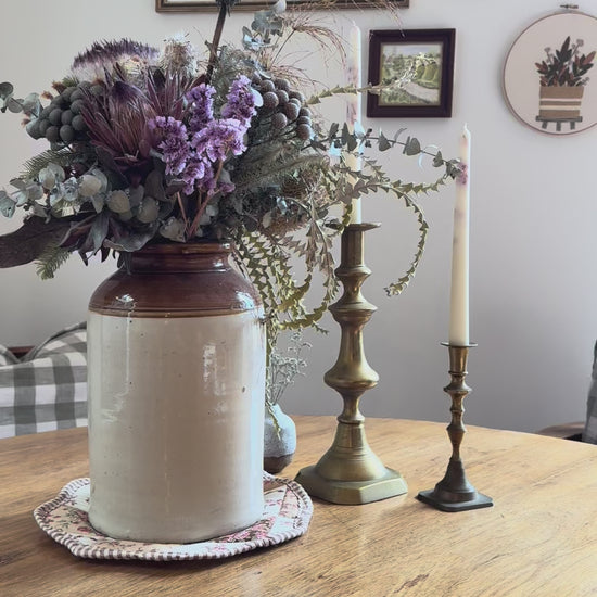 Inserting rattan reeds into butlers buttercream natural reed diffuser with a country table backdrop

